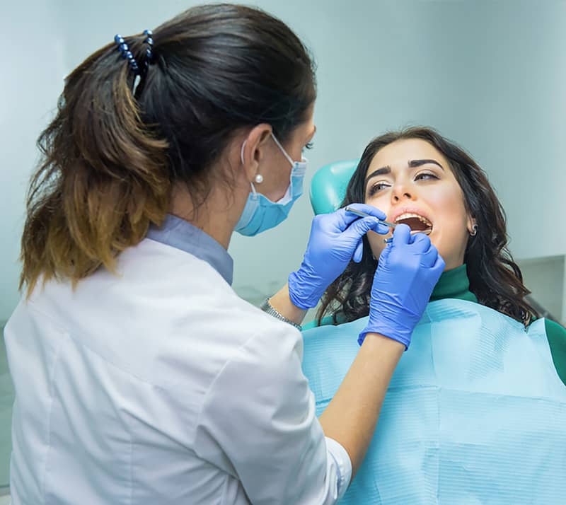dentist performing oral cancer screening