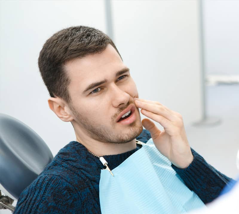 man experiencing pain and discomfort in his jaw due to TMD